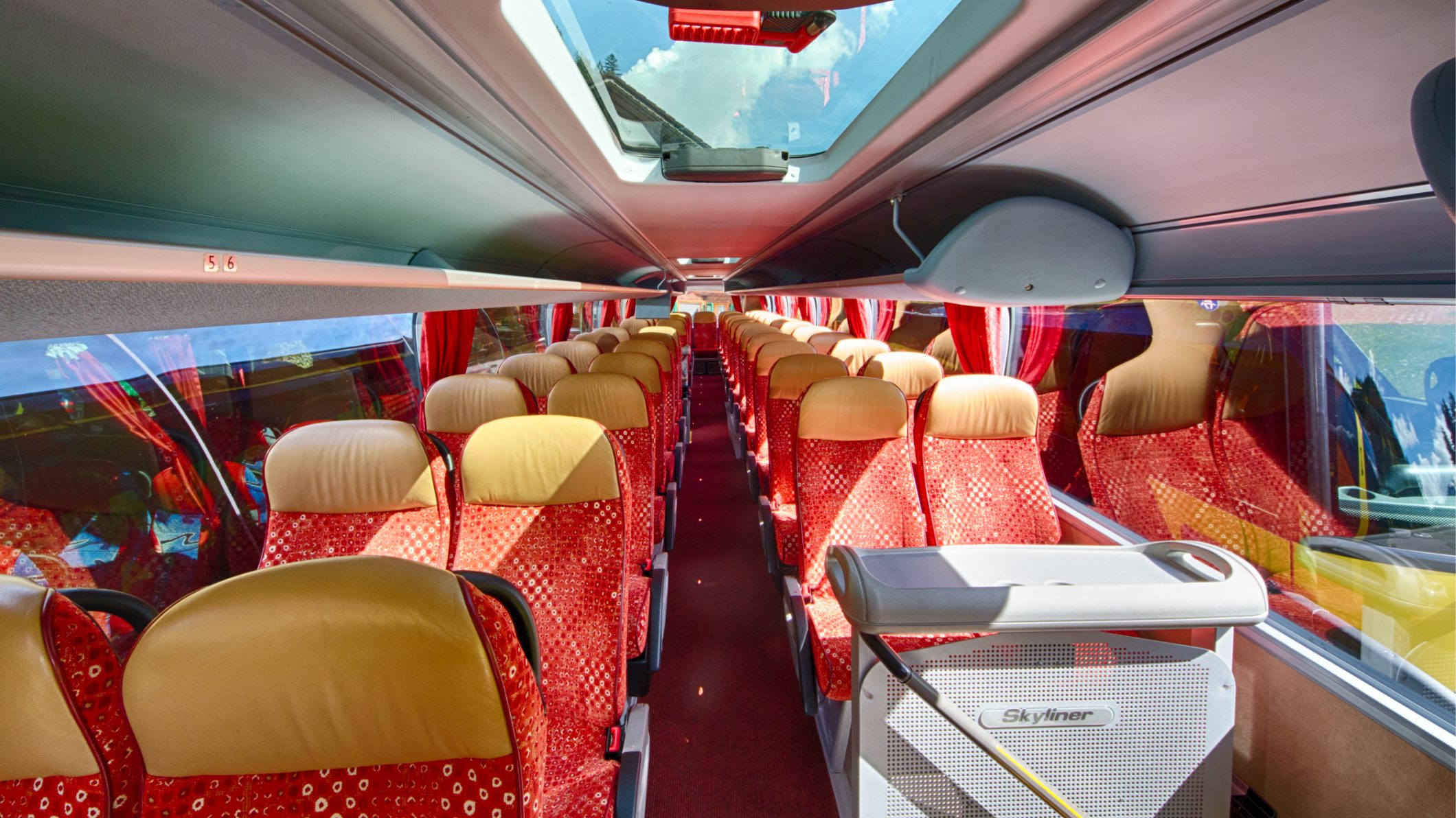 Das Interieur eines Reisecars von Neukomm für die Tagesmiete mit rotgelben Sitzen